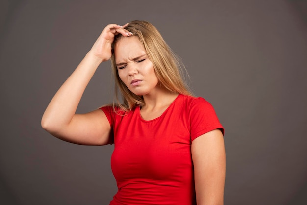 Free photo portrait of tired woman touching her head over dark background. high quality photo