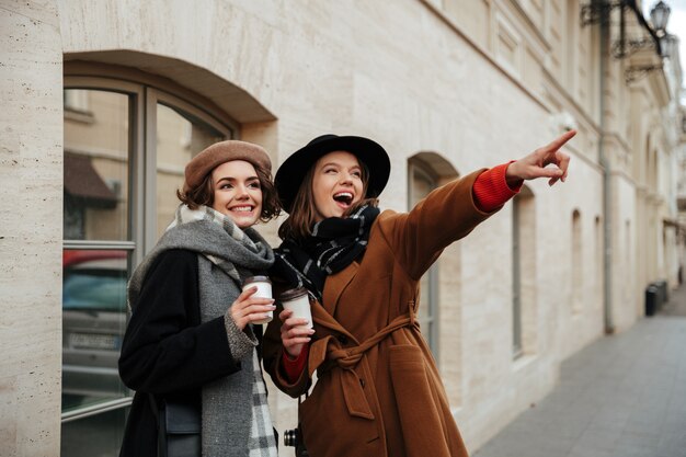 Portrait of two attractive girls dressed in autumn clothes