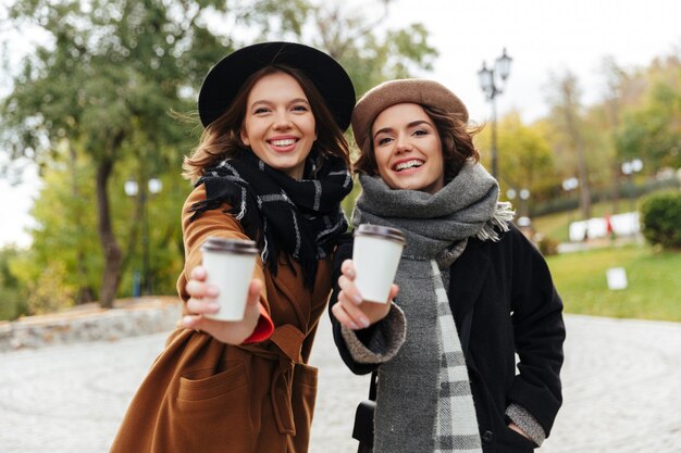 Portrait of two cheerful girls dressed in autumn clothes