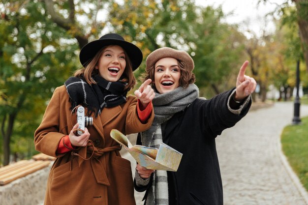 Portrait of two cheerful girls dressed in autumn clothes