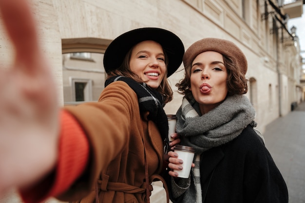 Portrait of two cheerful girls dressed in autumn clothes