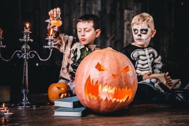 Portrait of two cool schoolboys in scary costumes during Halloween party in an old house. Halloween concept.