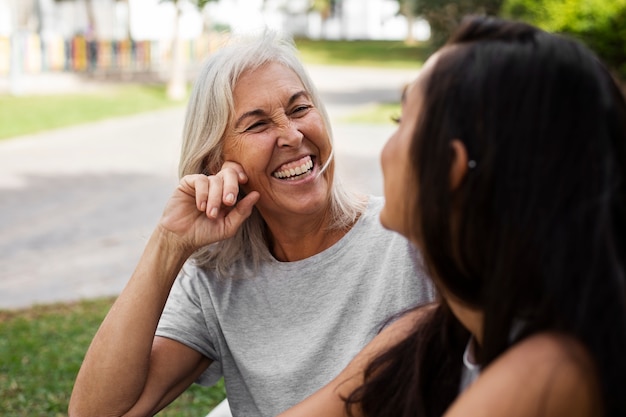 Foto gratuita ritratto di due amiche con età diverse all'aperto