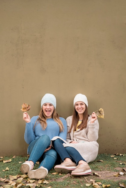 Portrait of two girls in front of a wall