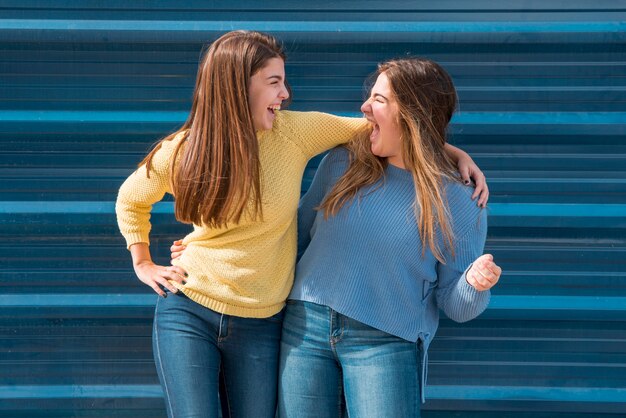 Portrait of two girls in front of a wall