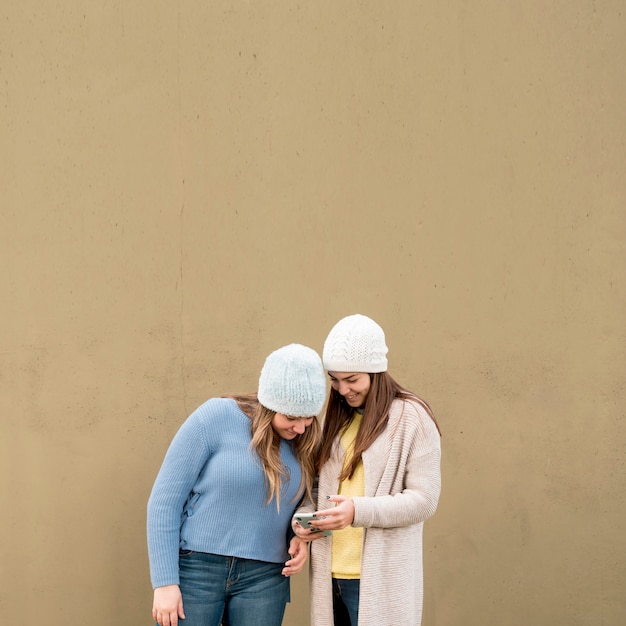 Portrait of two girls in front of a wall