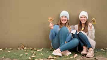 Free photo portrait of two girls in front of a wall