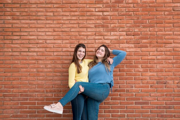 Portrait of two girls in front of a wall