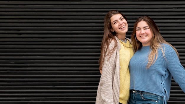 Portrait of two girls in front of a wall