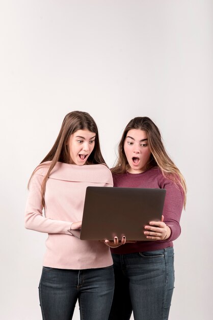 Portrait of two girls in front of a wall