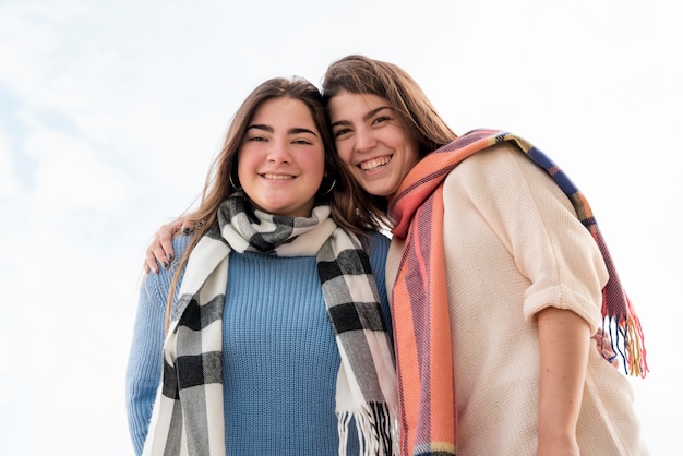 Foto gratuita ritratto di due ragazze sullo sfondo del cielo