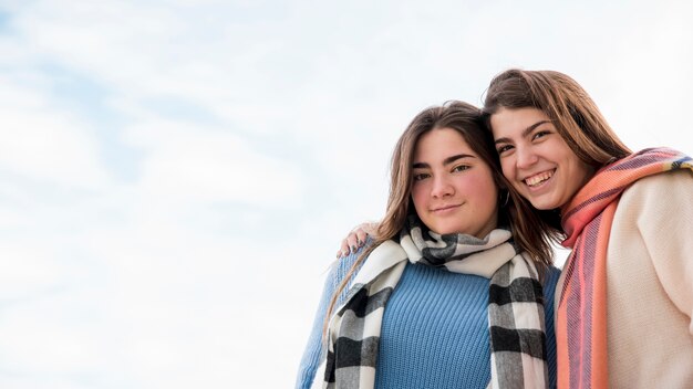 Portrait of two girls on sky background