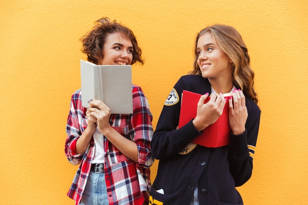 Foto gratuita un ritratto di due adolescenti graziosi felici con i libri