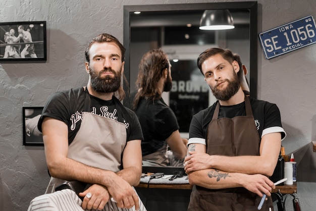 Free photo portrait of two male barbers looking at camera