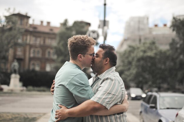portrait of two men kissing in the street