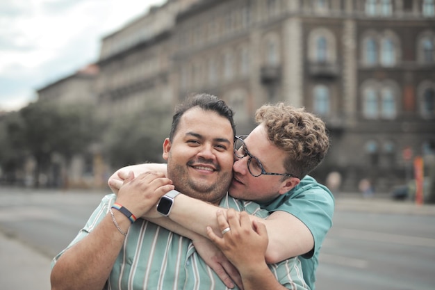 portrait of two men kissing in the street