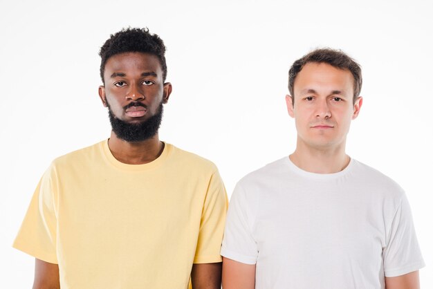 Portrait of a two men standing with arms folded isolated over white wall