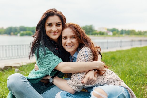 Portrait of two pretty girl friends smiling hugs and having fun