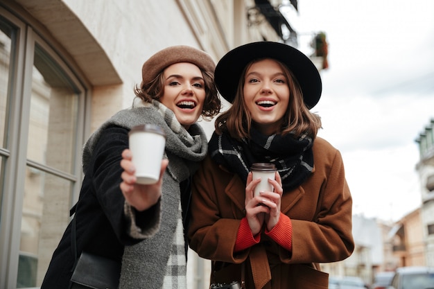 Portrait of two pretty girls dressed in autumn clothes walking