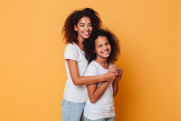 Portrait of two smiling african sisters hugging