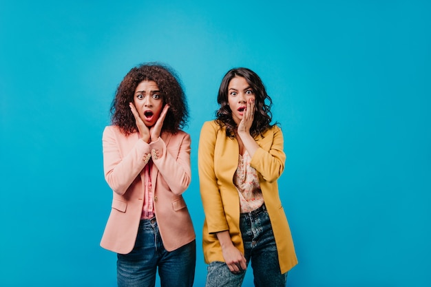 Portrait of two surprised women in colorful jackets
