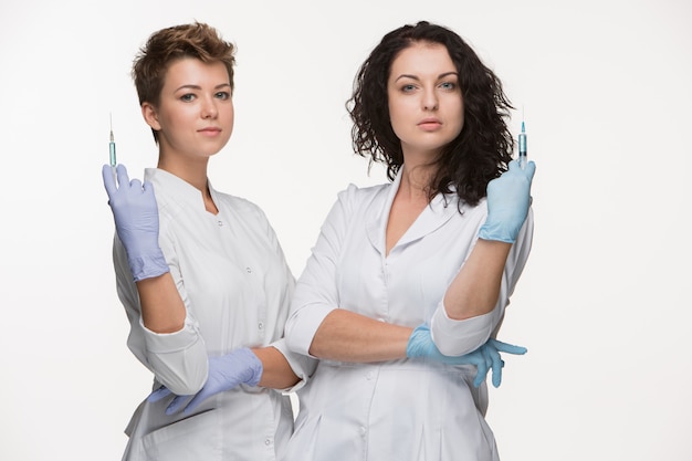 Портрет двух женщин-хирургов, показывая шприцы