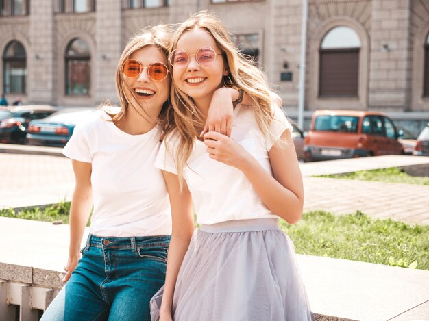 유행 여름 흰색 티셔츠 옷에 두 젊은 아름 다운 금발 웃는 hipster 여자의 초상화.