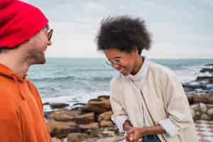 Free photo portrait of two young friends spending good time together and having fun with the sea in the space.