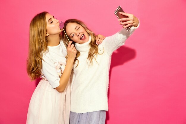 Portrait of two young stylish smiling blond women