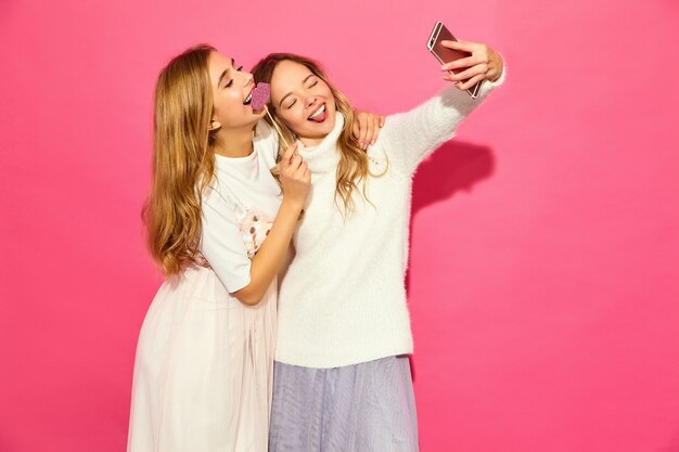 Portrait of two young stylish smiling blond women