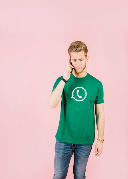 Free photo portrait of an unhappy young man talking on cellphone