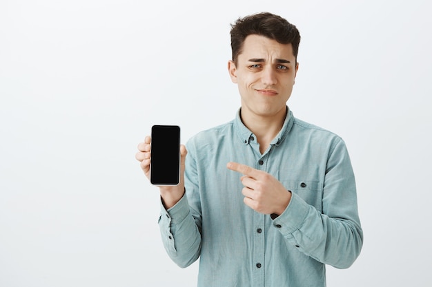 Portrait of unimpressed displeased young guy in shirt