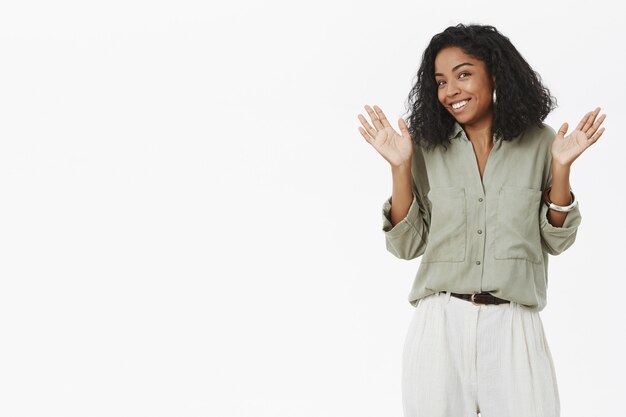 Portrait of uninvolved charismatic young dark-skinned employer in blouse raising palms