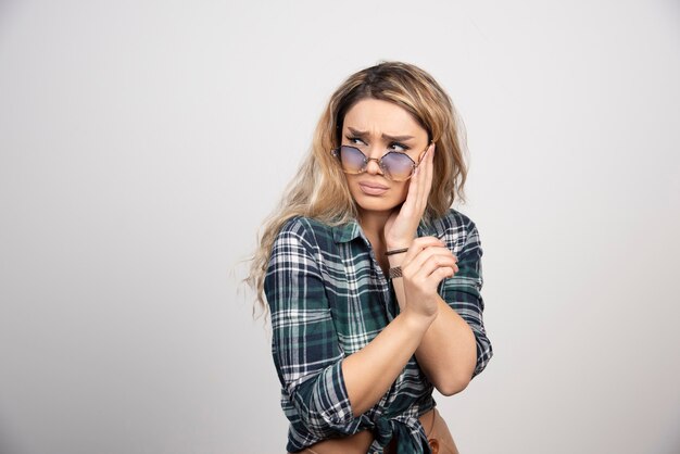 Portrait of upset woman wearing stylish glasses. 