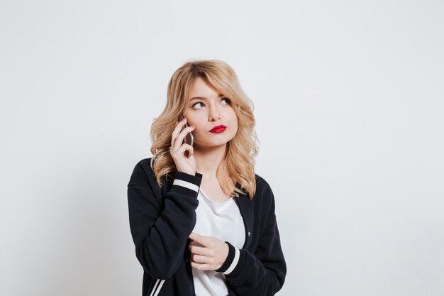 Portrait of an upset young casual woman talking on phone