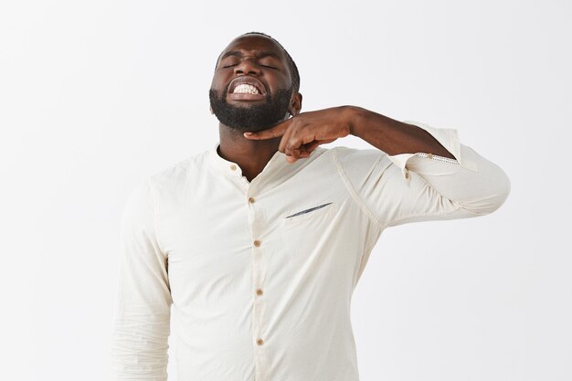 Portrait of upset young guy posing against the white wall