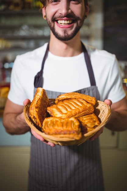Portrait of waiter holding a basket of bread