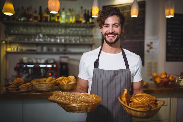 Portrait of waiter holding a basket of bread