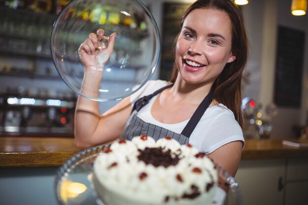 Portrait of waitress holding a plate of cake