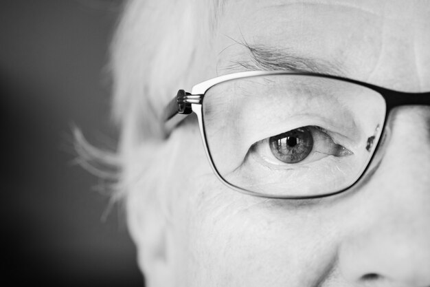 Portrait of white elderly woman closeup on eyes wearing specatac