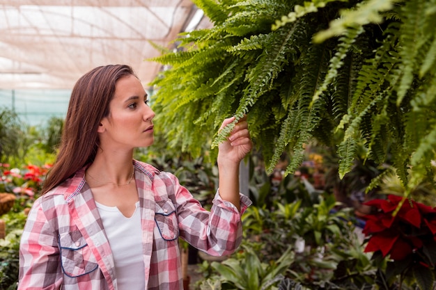 Portrait of woman admiring plants in garden