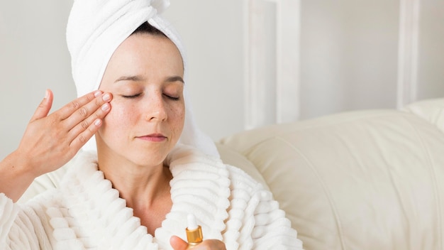 Free photo portrait of woman applying cream