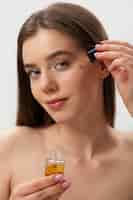 Free photo portrait of woman applying serum on face