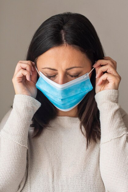 Portrait of woman arranging medical mask