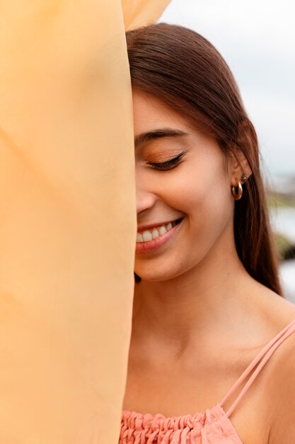 Portrait of woman at the beach hiding her face behind veil