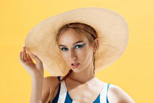 Portrait of a woman on a beach wearing a hat