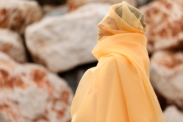 portrait of woman at the beach with face covered by veil