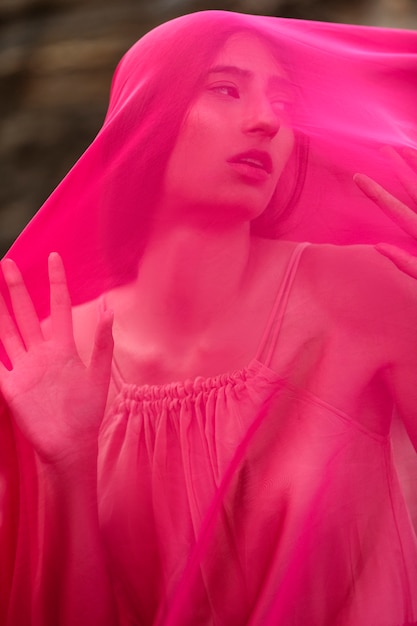 Portrait of woman at the beach with face covered by veil