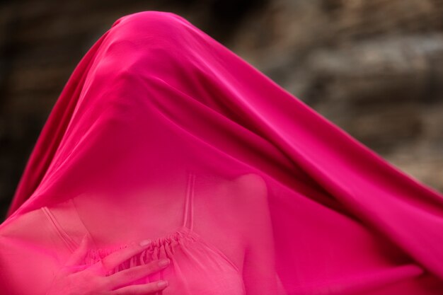 Portrait of woman at the beach with face covered by veil