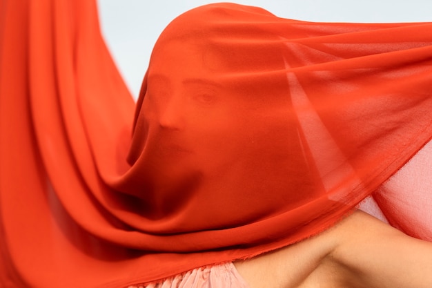 Free photo portrait of woman at the beach with face covered by veil